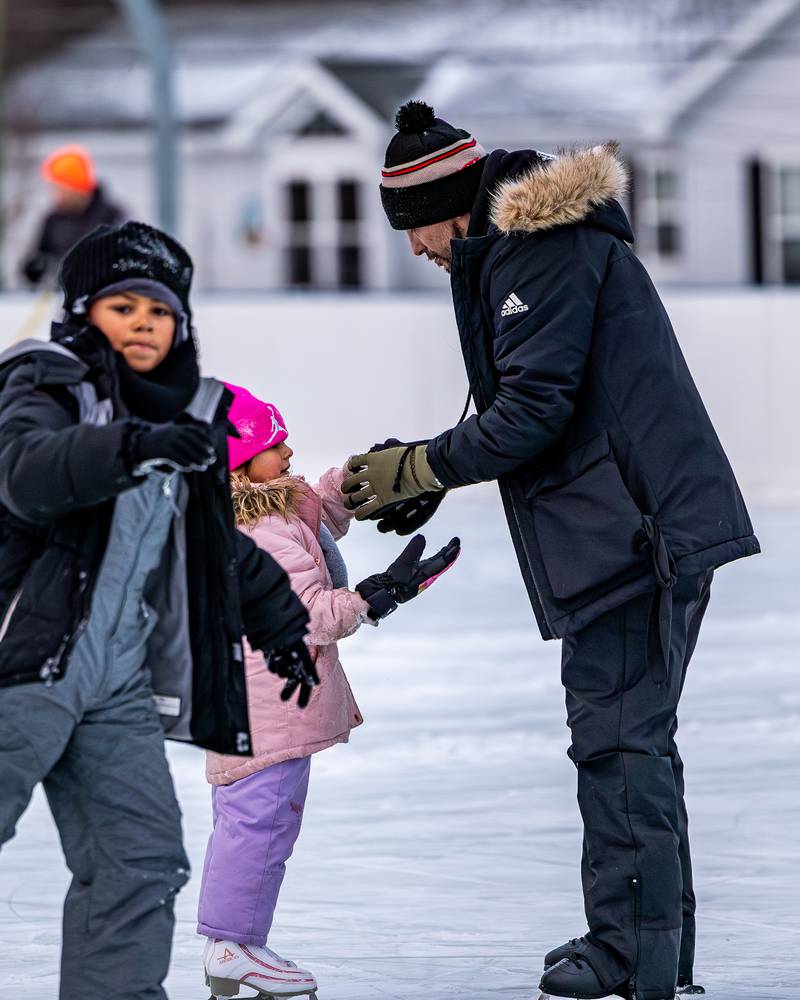 Amilena Policky is helped by father Richie Policky to put on gloves at Schweickert Arena's Ice Rink on Tuesday, December 30, 2025, at Washington Park in Peru.