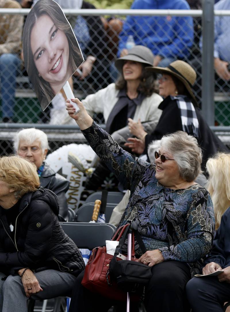 Laurie Parker waves a picture of her granddaughter, Madison Zilm, Saturday, May 13, 2023, during the graduation ceremony for class of 2023 at Crystal Lake South High School in Crystal Lake.