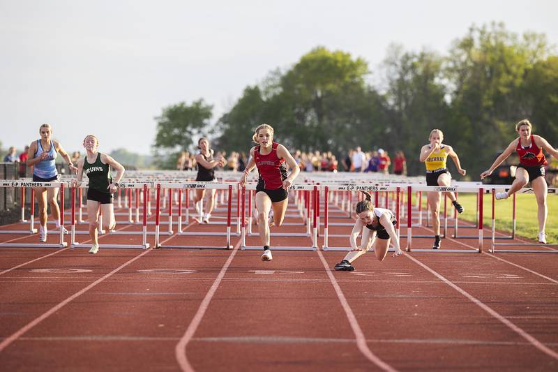 Amboy’s Elly Jones looks for the finish line as Fulton’s Emery Wherry loses her footing in the 100 hurdles Wednesday, May 10, 2023 at the class 1A Erie girls track sectional.