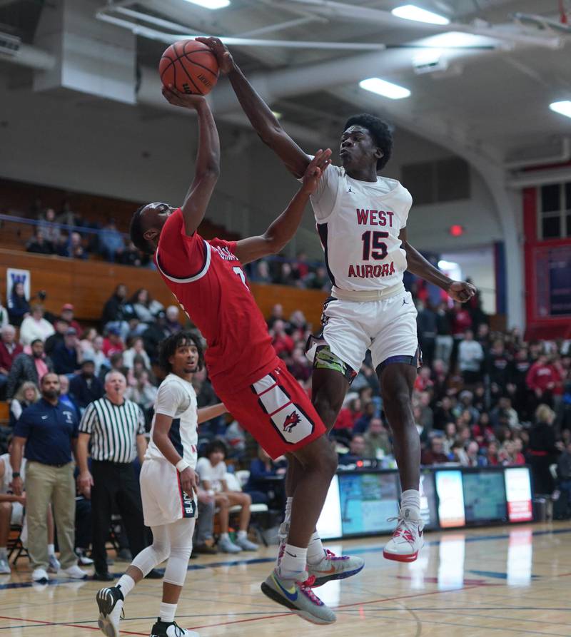 West Aurora's Kewon Marshall (15) blocks a shot by Yorkville's Dayvion Johnson (3) during a basketball game at West Aurora High School on Tuesday, Nov 28, 2023. (Sean King for Shaw Local News Network)