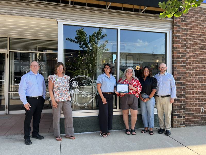 Three Wishes was honored on Monday, July 14, 2025, outside their storefront as the chamber's business of the month. Pictured are (from left) Ben Hiltabrand, Chamber president; Lori Snell, Chamber vice president; Three Wishes co-owners Carrie Schmitz, Kim Tutoky and Jodie Hoffmeyer, and Derek Barichello, Chamber executive director.