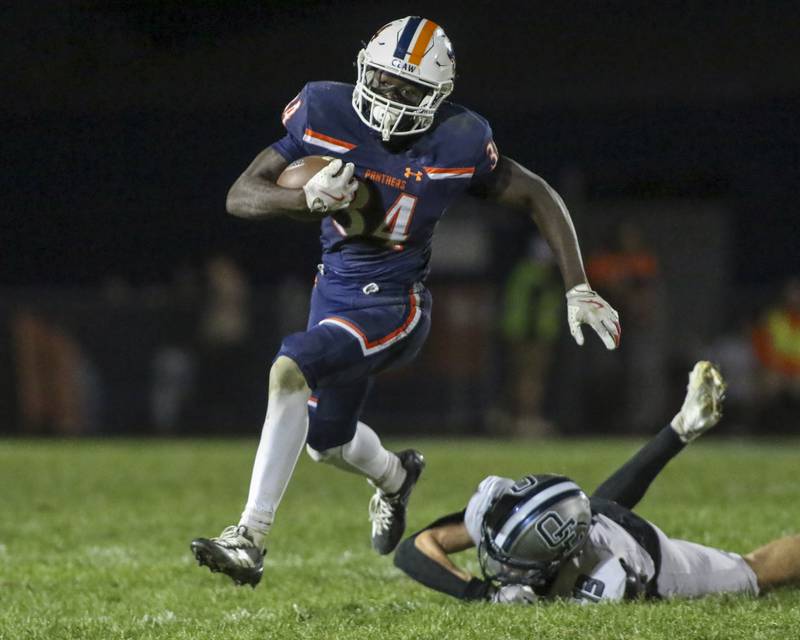 Oswego's Ammar Banire (34) runs away from Oswego East's Michael Prioriello (13) during football game between Oswego East at Oswego Friday, Oct 17, 2025 in Oswego.