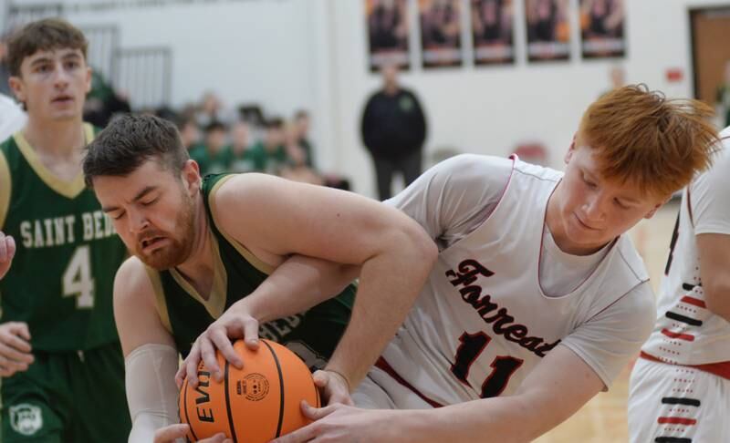 Forreston's Connor Politsch (11) and Peru St. Bede's Mason Ross (13) battle for the ball during Wednesday, Feb. 26, 2025 action at the 1A Amboy Regional at Amboy High School. The Cardinals won the game  67-56 to advance to the regional championship game on Friday against Annawan.