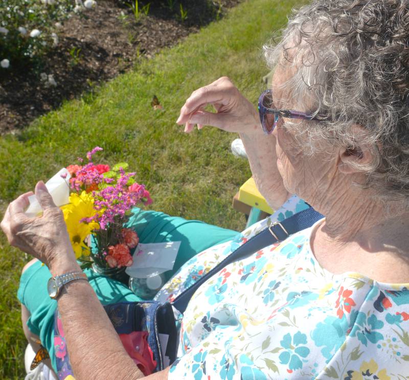 Doris Peterson of Byron watches as her monarch butterfly leaves the flowers she brought to the Serenity Hospice & Home Memorial Butterfly Release on Saturday, July 8, 2023, in Oregon. Peterson released the butterfly in memory of her husband, Carl, and friend, Ferd Fransen.