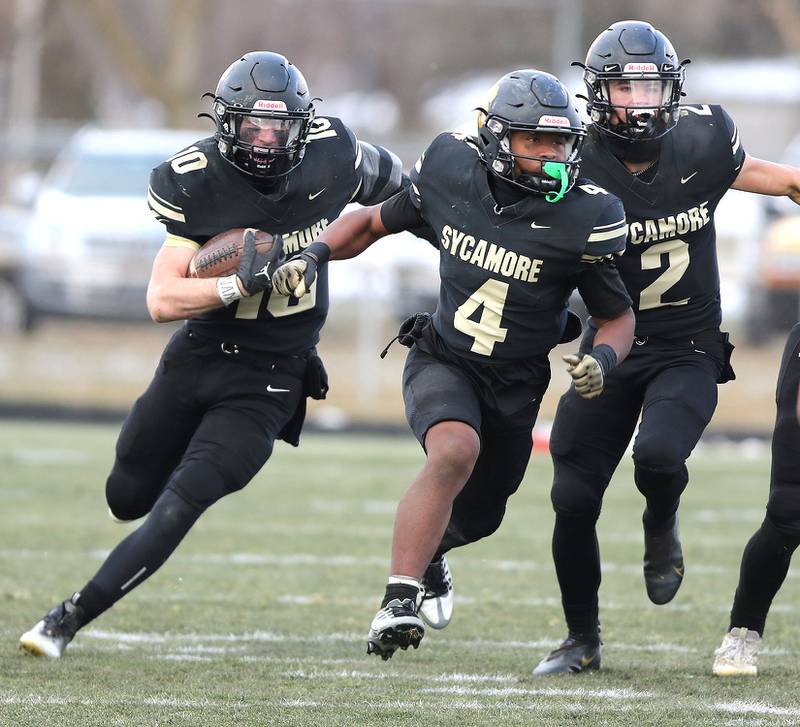 Sycamore's Zack Crawford (left) follows Tyler Curtis and Elijah Meier (right) through the Nazareth defense Saturday, Nov. 18, 2022, during the state semifinal game at Sycamore High School.