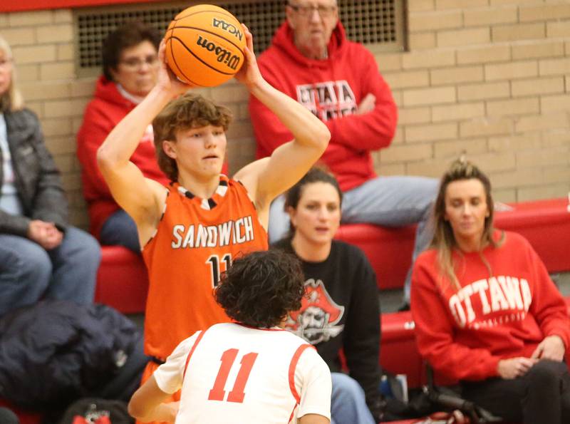 Sandwich's Nick Michalek looks to pass the ball off as Ottawa's Hezekiah Joachim defends on Wednesday, Dec. 4, 2024 in Kingman Gym at Ottawa High School.
