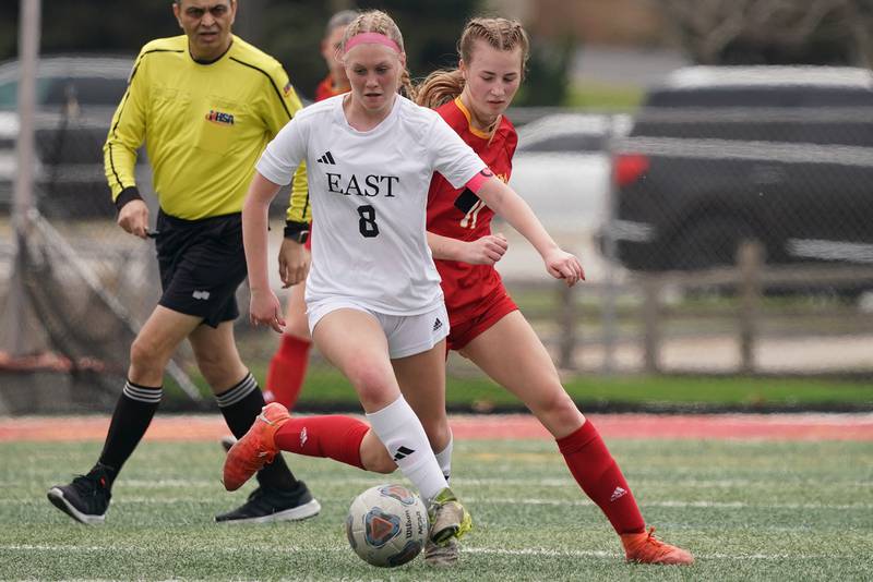 Oswego East's Natalie Hamilton (8) plays the ball against Batavia’s Emma Wecker during a soccer match at Batavia High School on Saturday, March 29, 2025.