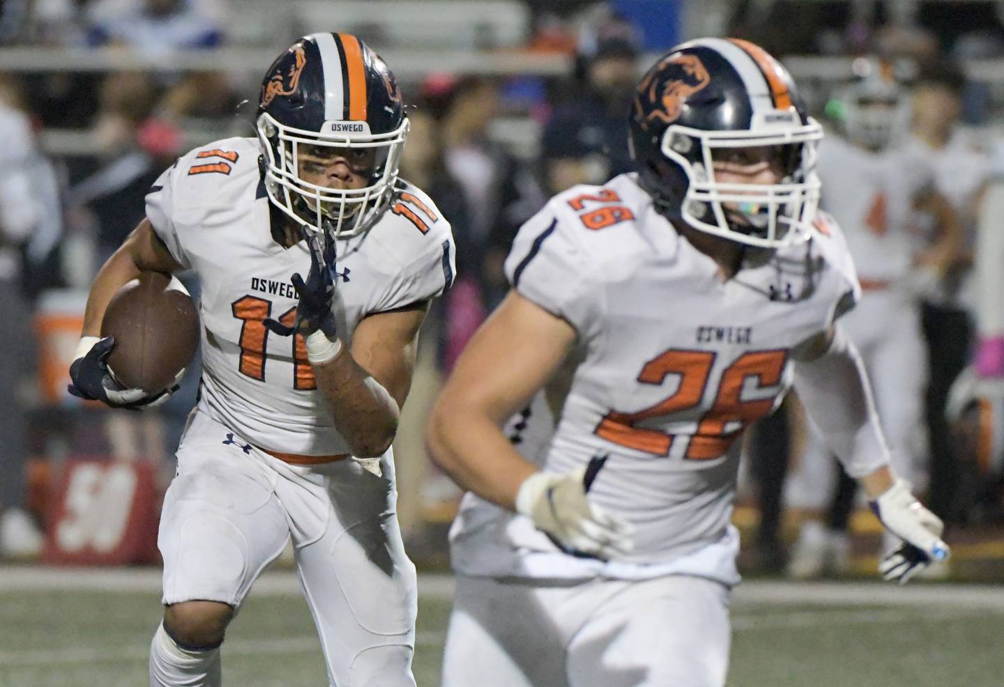 Oswego's Mark Melton (11) runs the ball against West Aurora during a game in Aurora on Friday, October 8, 2021.