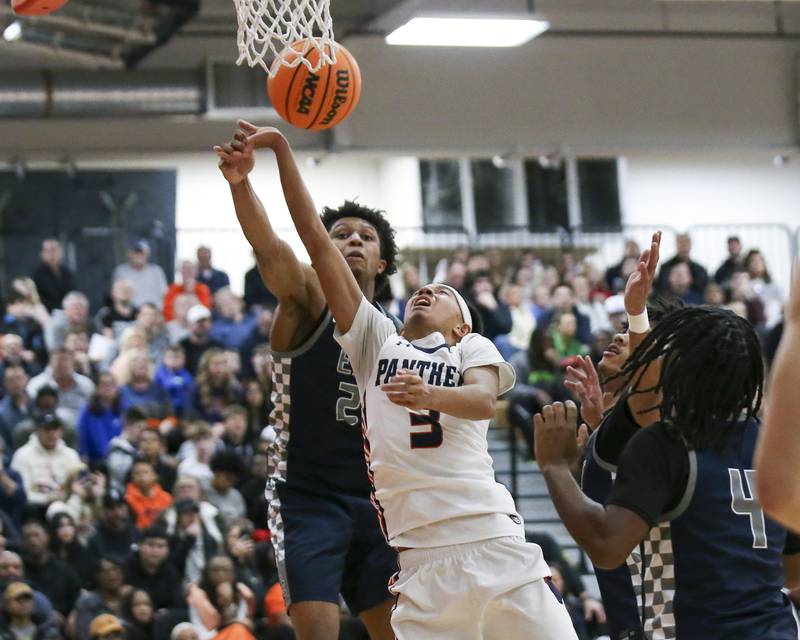 Oswego East's Dshaun Bolden (24) blocks a shot attempt by Oswego's Ethan Vahl (3) during their basketball game between Oswego East at Oswego Friday, Jan 09, 2025 in Oswego.