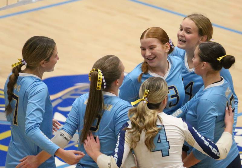 Members of th Marquette volleyball team react after scoring a point against Serena on Wednesday, Oct. 22, 2025 in Bader Gymnasium at Marquette High School.