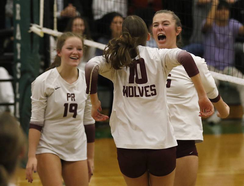 Prairie Ridge's Adeline Grider (right) celebrates a point with teammates, Tegan Vrbancic (left) and Addison Smith (center) during the IHSA Class 3A Grayslake Central Supersectional volleyball match against St. Francis on Monday, Nov. 11, 2024, at Grayslake Central High School.