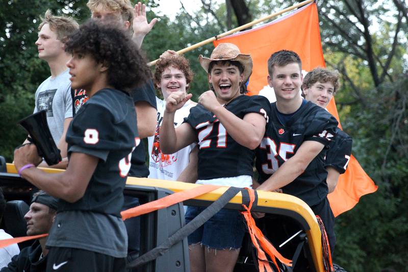 Members of the Wheaton Warrenville South football team ride atop a Bronco during the school’s homecoming parade on Wednesday, Sept. 21, 2022.
