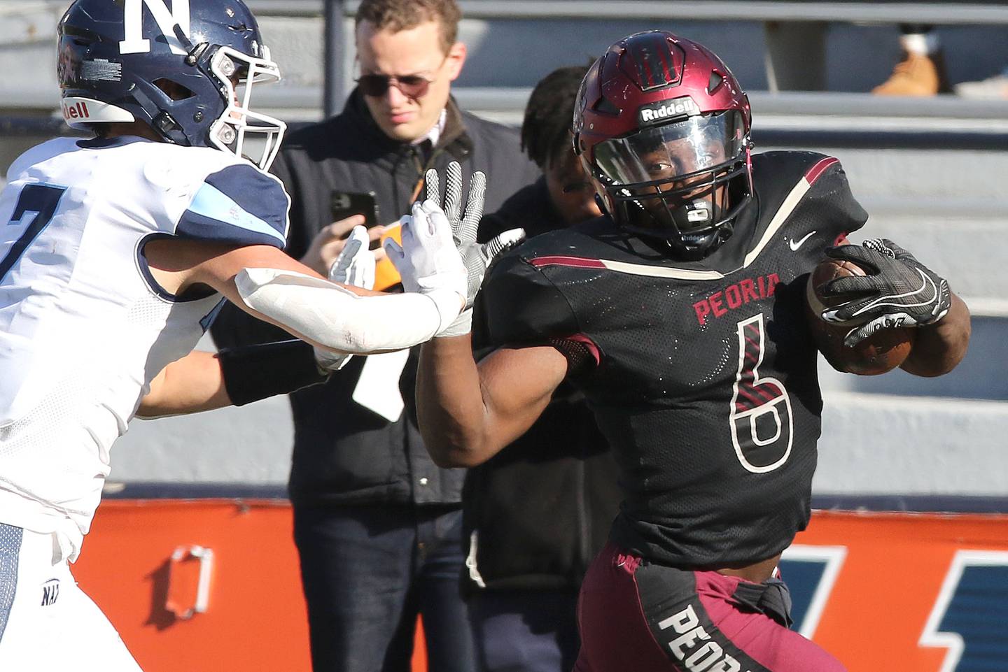 Peoria's Malachi Washington stiff arms Nazareth's Zach Hayes after a long gain during their IHSA Class 5A state championship game Saturday, Nov. 26, 2022, in Memorial Stadium at the University of Illinois in Champaign.