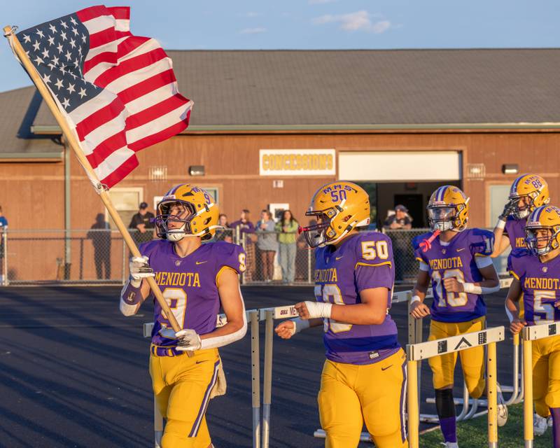 Gavin Evans prepares to run the American Flag onto the field at the start of the game against Newman Central Catholic High School at The Jeff Prusator Athletic Complex on September 5, 2025 at Mendota High School.