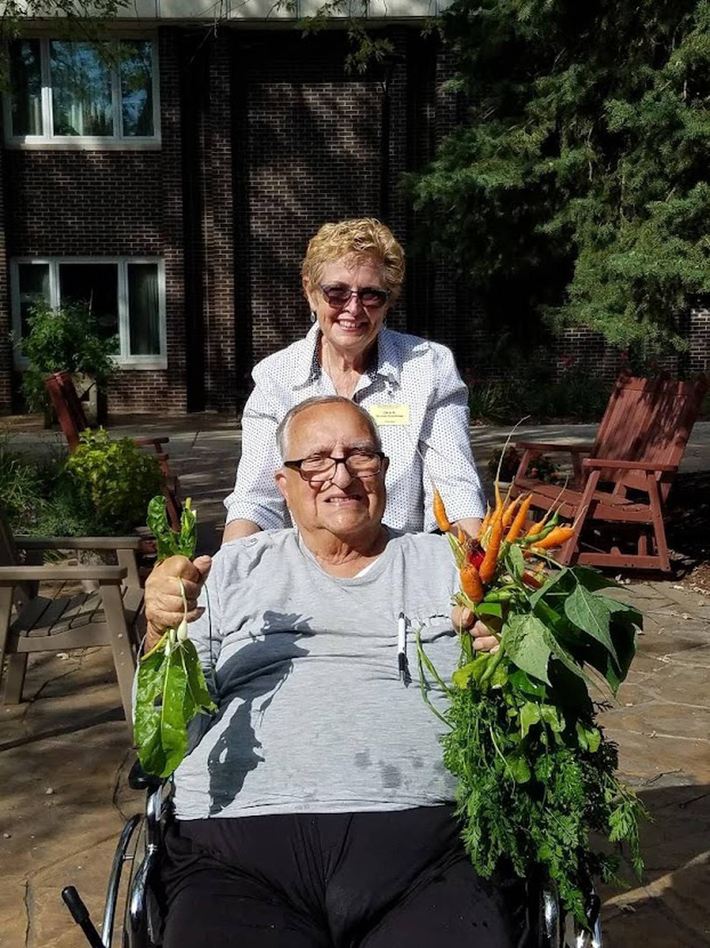 Illinois Extension Master Gardener volunteer Chris Blecker and participant Ralph show off produce grown in the gardens at Sunny Hill Nursing Home of Will County in Joliet, a Master Gardener project.