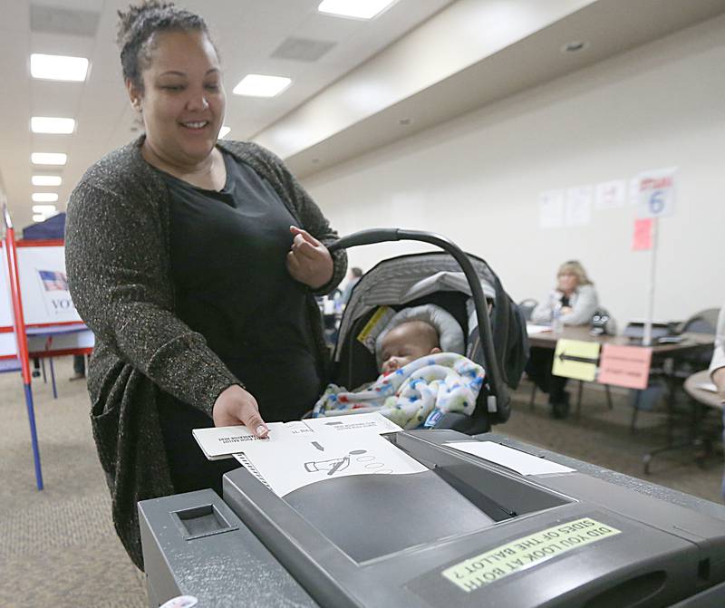 Alexis Martinez casts her ballot while carrying her four month old son Henry at the Knights of Columbus Hall on Tuesday, Nov. 8, 2022 in Ottawa.