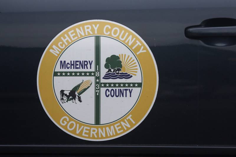 The McHenry County Government logo on the side of a vehicle parked outside the McHenry County Administration Building in Woodstock on Monday, Nov. 20, 2023. The McHenry County Board is schedule to vote on the county budget this evening.