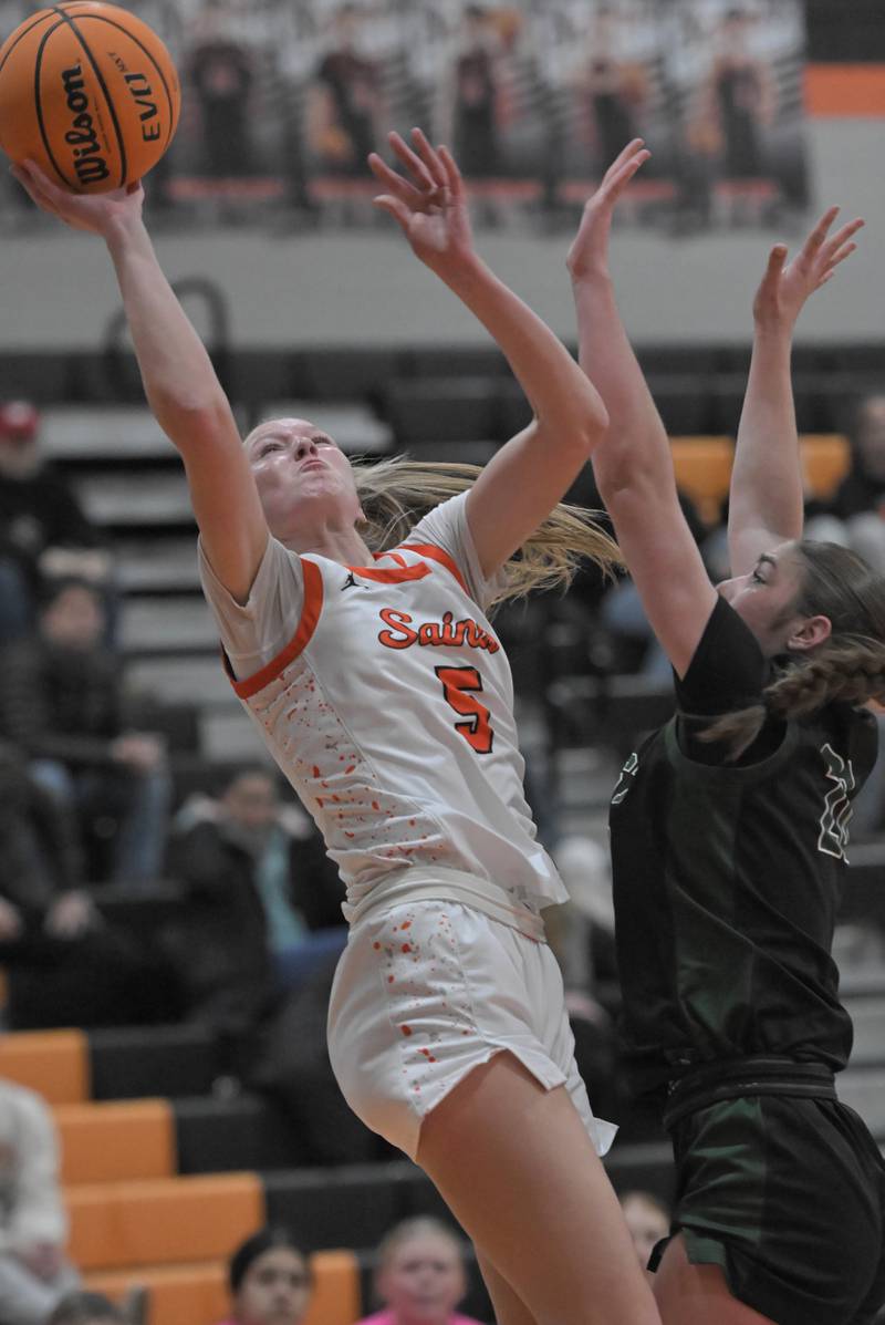 St. Charles East’s Brooklyn Schilb shoots around Glenbard West’s Ellie Noble in a girls basketball game in St. Charles on Tuesday, Jan. 28, 2025.