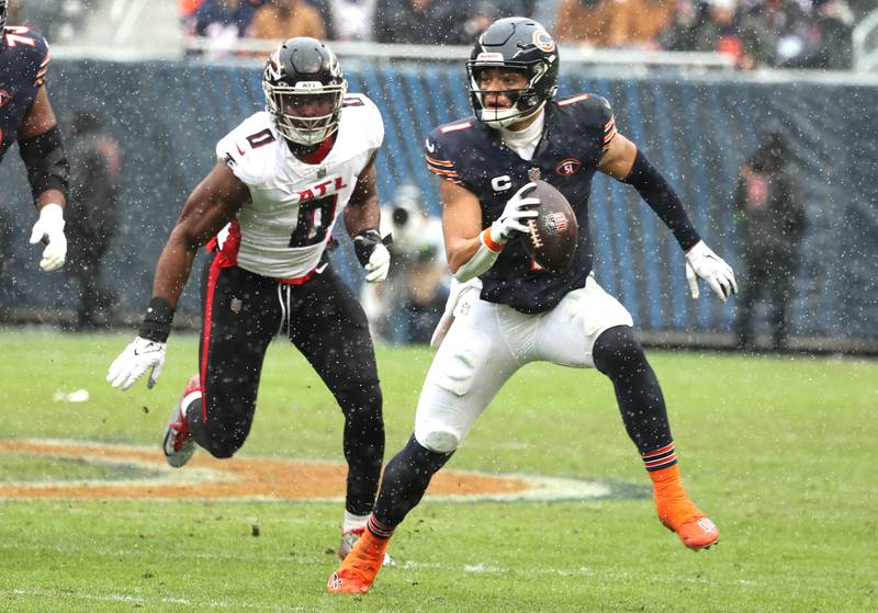 Chicago Bears quarterback Justin Fields avoids the Atlanta Falcon pass rush and picks up yardage during their game Sunday, Dec. 31, 2023, at Soldier Field in Chicago.