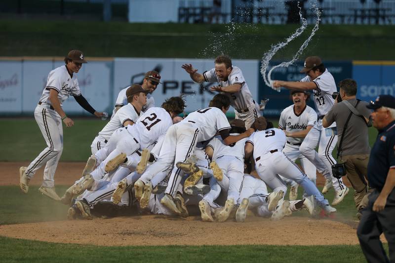 Joliet Catholic rushes the mound on the final out of the Hillmen’s 12-3 win over Richmond-Burton in the IHSA Class 2A championship game. Saturday, June 4, 2022 in Peoria.