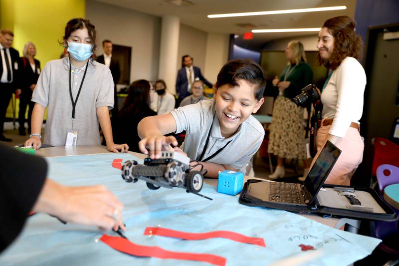 Cicero District 99 fifth grader Noah Maldonado shows a project he helped with to district officials along with representatives from Project Lead the Way and engineering and architecture firm Burns and McDonnell. The district was recently awarded with a $260,000 grant to expand its STEAM education with Project Lead The Way, courtesy of a grant from Burns & McDonnell.