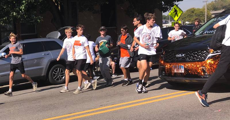 Members of the McHenry High School cross country team run at the McHenry High School Homecoming parade Oct. 6, 2024.