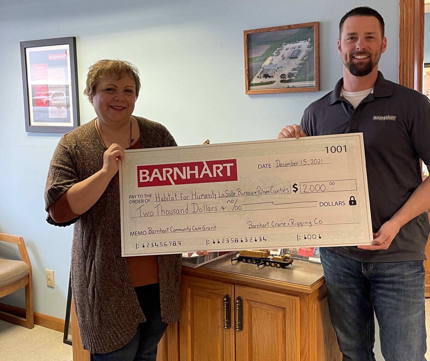 Matt Fiorentini, branch manager for Barnhart Crane and Rigging Co. in Ladd, presents a Barnhart Community Care Grant to Habitat for Humanity La Salle, Bureau and Putnam counties for $2,000.