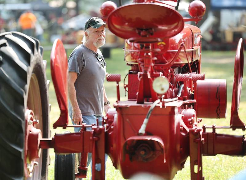 Lenny Stuba, from Maple Park, checks out one of the many tractors on display during the Sycamore Steam Show Thursday, Aug. 10, 2023, at Taylor Marshall Farm in Sycamore. The show runs from 7 a.m. to 5 p.m. through Sunday.