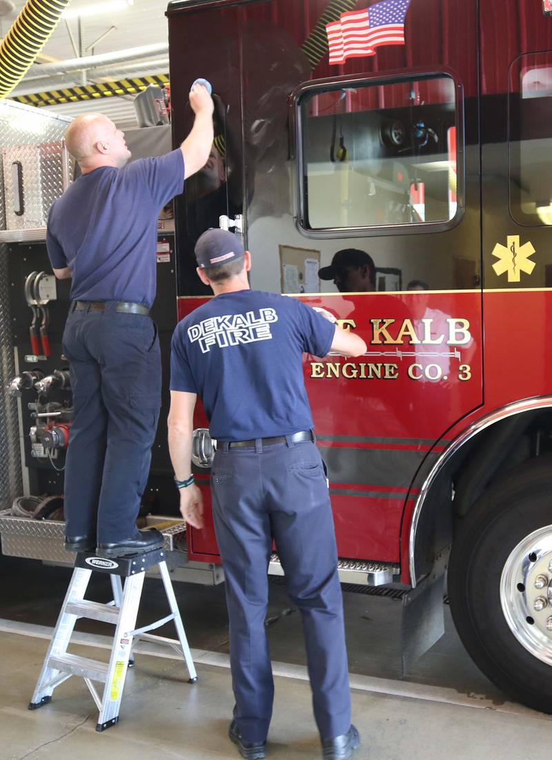 DeKalb firefighters wax the departments newest engine Tuesday, May 16, 2023, in the apparatus bay at Fire Station 3 in DeKalb.