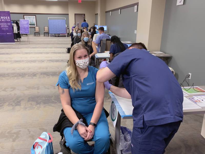 Emergency department technician Krystal Caha receives the Moderna COVID-19 vaccine from nurse practitioner Charles Samuel Tuesday, Dec. 29, 2020, at Northwestern Medicine Huntley Hospital.