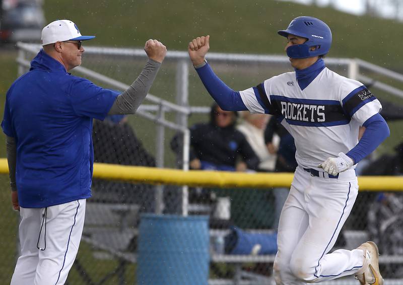Burlington Central's Andrew Payton celebrates his grand slam home run with coach Kyle Nelson during a Fox Valley Conference baseball game against Crystal Lake South on Friday, April 12, 2024, at Burlington Central High School.