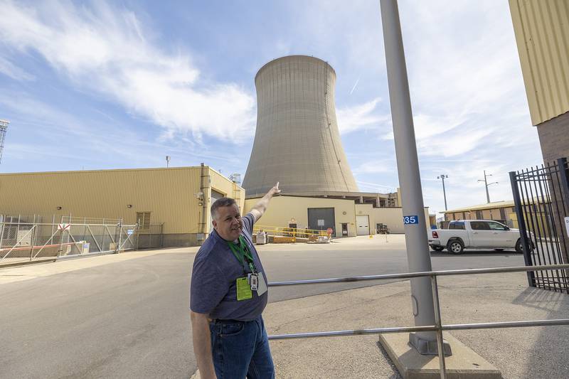 Paul Dempsey, Generation Communications Manager for Constellation, gestures at the cooling tower of Plant 2 at the Byron nuclear power facility Wednesday, April 16, 2025. The plant, one of two at the station, was shut down for refueling.