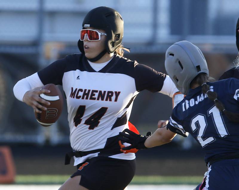 McHenry's Brooklyn Anderson runs with the ball as Cary-Grove's Claire Williams tries to grab her flag during the IHSA McHenry Regional girls flag football championship game on Wednesday, Oct. 8, 2025, at McCracken Field in McHenry.