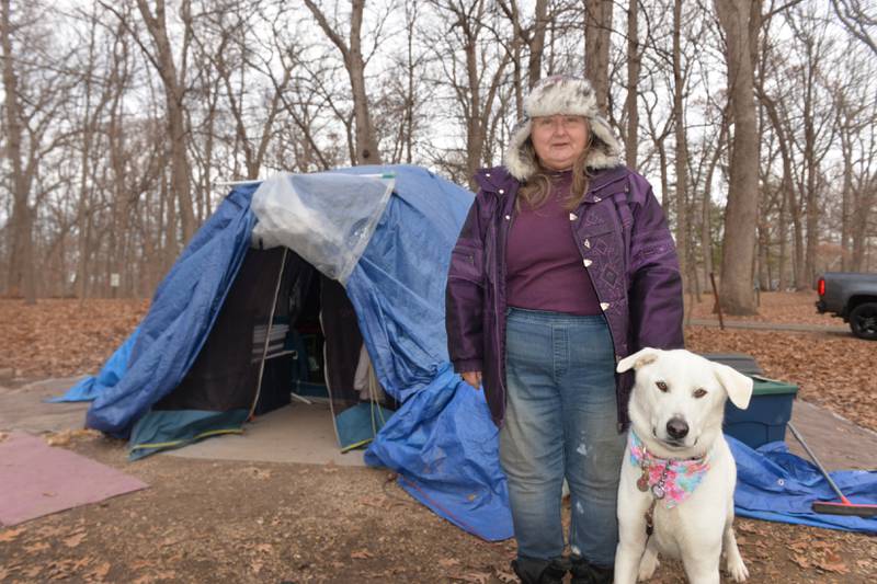 Sarah Wright and her dog Luna, stand by their tent at their campsite in Lowden State Park on Friday, Dec. 15, 2023. Wright and Luna have been camping at Lowden State Park after being without a home for several months. Local residents have been helping Wright since reading about her plight on social media.