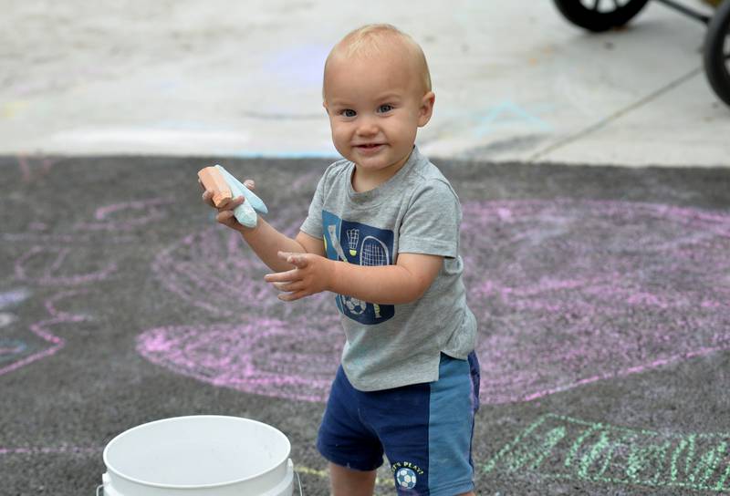 Alexander Ring, 1, of Oregon, was busy creating with sidewalk chalk during the grand opening celebration for the newly upgraded Oregon Park East Inland Side recreation area on Monday, May 18, 2026.