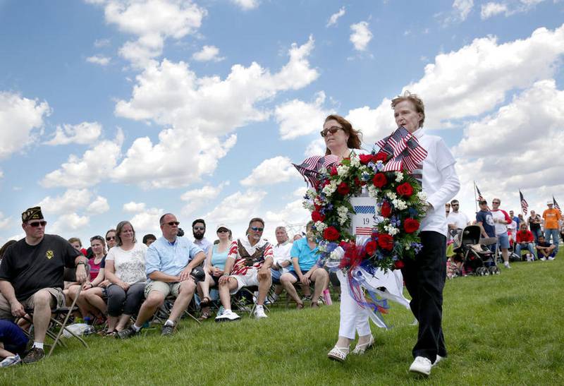 Denise Meehan and Linda Pahnke carry a special Gold Star mothers wreath Monday, May 30, 2016, during a Memorial Day ceremony at Abraham Lincoln National Cemetery in Elwood.