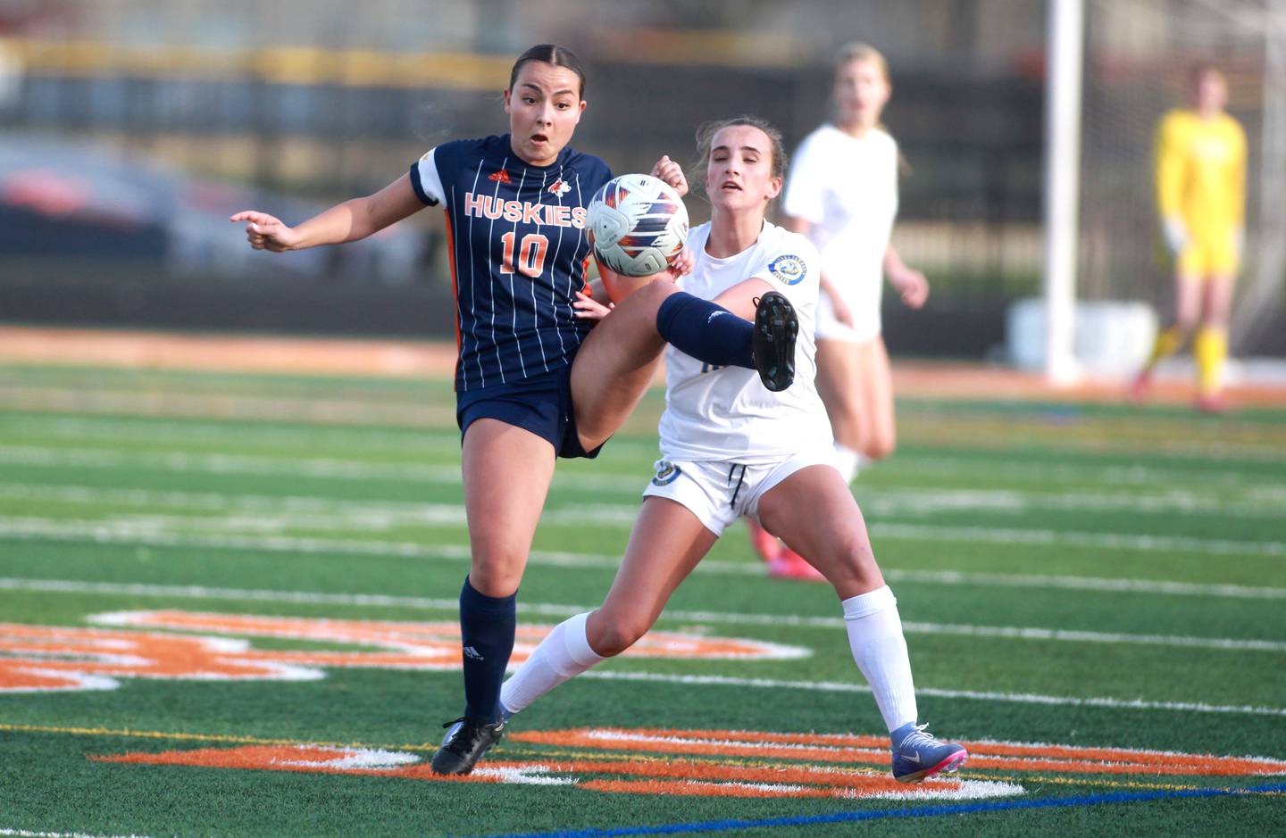 Naperville North's Sophia Houston kicks the ball away from Lyons Township's Lila Tower during a game on Wednesday, April 16, 2025 in Naperville.