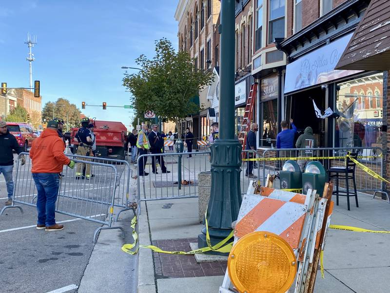 Authorities build a barricade and walkway to keep pedestrians safe and away from debris on Friday, Oct. 24, 2025, after a building in the 300 block of West State Street in downtown Sycamore was damaged when a white SUV crashed into the front of Atlas Roots Collective, 330 W. State St., police said.