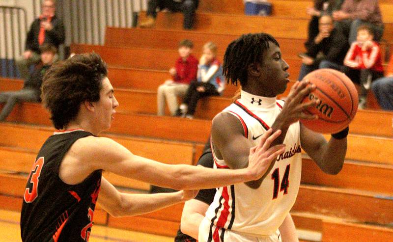 Crystal Lake Central’s Jackson Hopkins, left, keeps tabs on Huntley’s Sheldon Bonsu during tournament basketball action at Johnsburg High School Monday evening.
