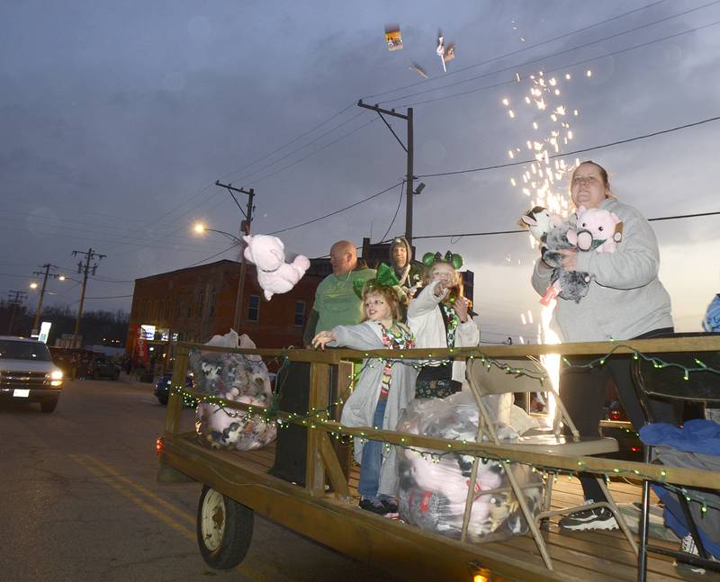 One of the floats in the Marseilles Lighted St Patrick’s Day Parade Saturday provided some fireworks as well as tossing stuffed animals to those along the parade route .