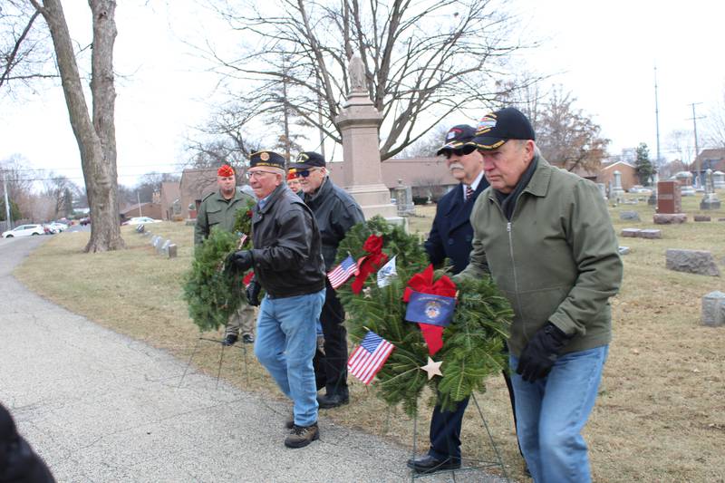 American Legion members carry wreaths representing the branches of the U.S. military at Union Cemetery on Dec. 14, 2024, in Crystal Lake during the Wreaths Across America ceremony.
