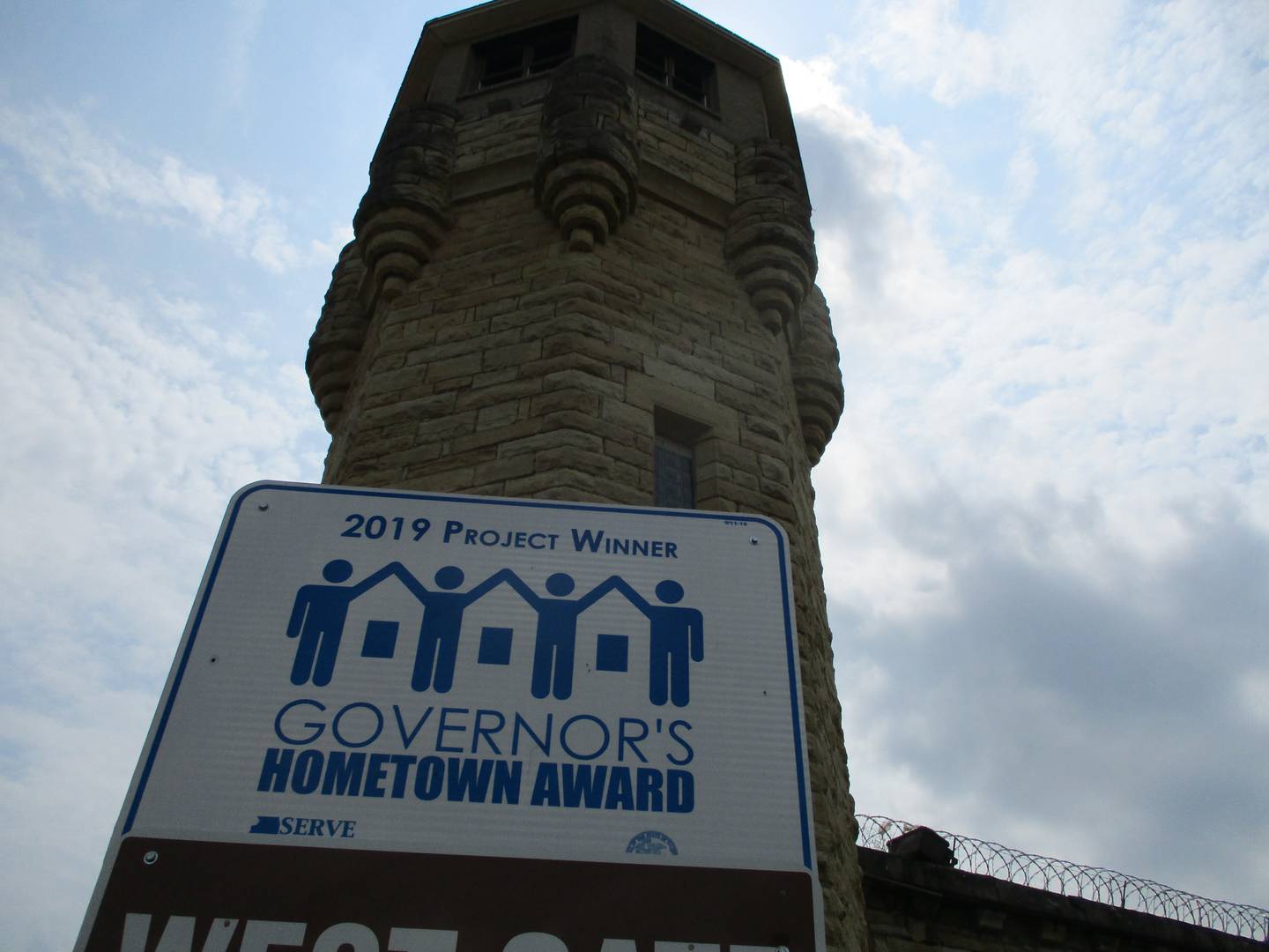 A sign along Collins Street outside the old Joliet Jail states the state;  recognition for Joliet's efforts to restore the former Joliet Correctional Center.