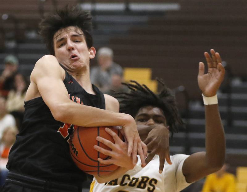 McHenry's Hayden Stone grabs a rebound in front of Jacobs' Treval Howard during a Fox Valley Conference basketball game Wednesday, Dec. 7, 2022, between Jacobs and McHenry at Jacobs High School in Algonquin.