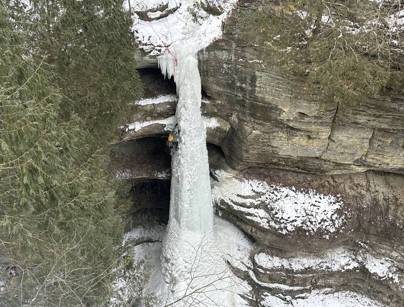 An ice climber climbs up a 90-foot tall frozen waterfall on Sunday, Jan. 21, 2024 in Starved Rock State Park.