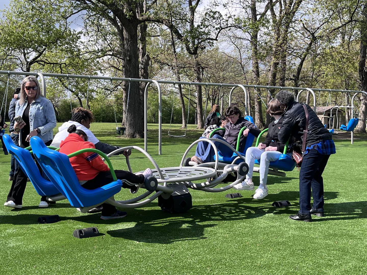 Attendees at a ribbon-cutting ceremony enjoy the new playground features at Inwood Park on Friday, May 1, 2026, in Joliet that's meant to encourage connection and inclusiveness.