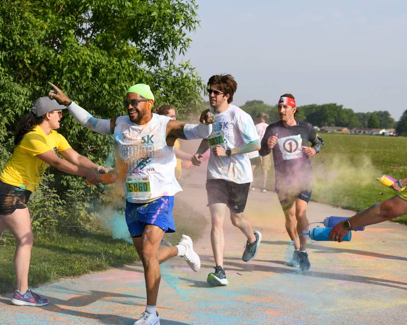 Participants get sprayed with color powder as they run through a color station on Saturday, June 7, 2025, during the CASA DeKalb County 5K Color Run held at the Sycamore Middle School.