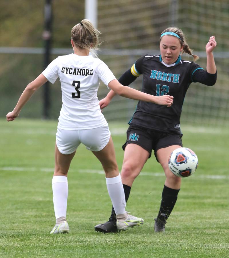 Woodstock North's Mackenzie Rogers kicks the ball past Sycamore's Jetta Weaver during their IHSA Class 2A regional game Tuesday, May 17, 2022, at Burlington Central High School.