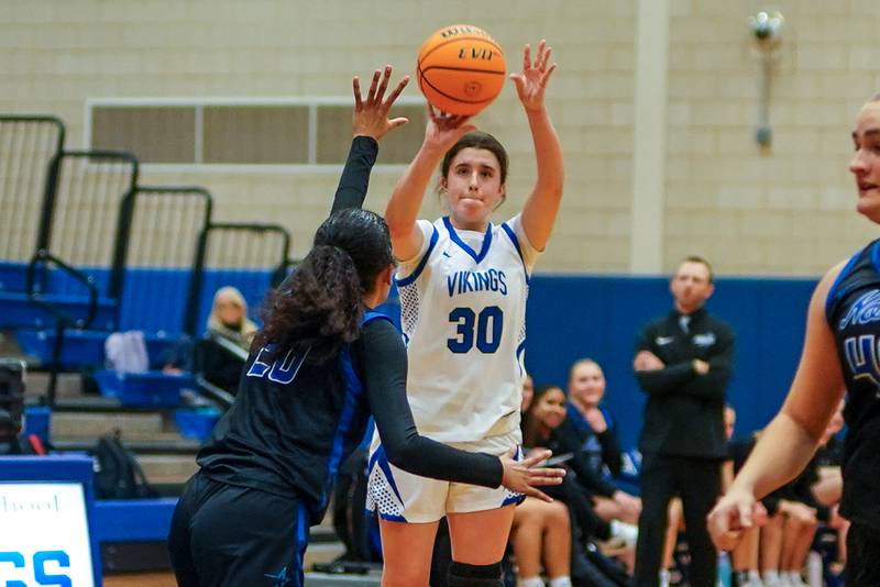 Geneva’s Keira McCann (30) shoots a 3-pointer against St. Charles North's Sydney Johnson (20) during a game at Geneva High School on Thursday, Dec. 4, 2025.