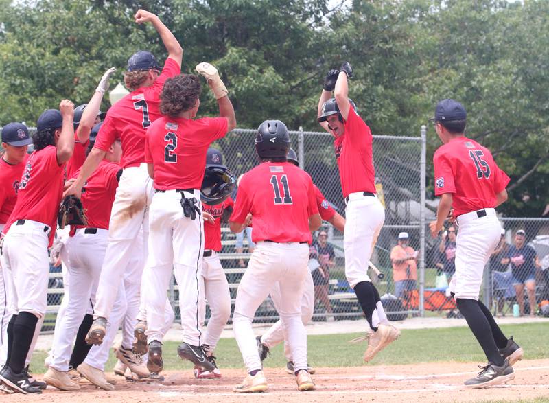 Members of the Burbank baseball team celebrate after player Danny Coyle (right) smacked a three-run home run against Spring Valley during the Central Regional Senior Baseball Regional tournament at J.A. Happ Field in Washington Park in Peru.