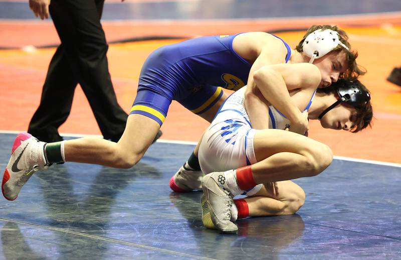 Marmion’s Nicholas Garcia works to escape from Rocco Hayes during their Class 3A 106 pound 3rd place match in the IHSA individual state wrestling finals in the State Farm Center at the University of Illinois in Champaign.